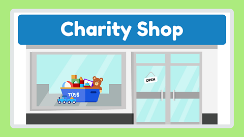 An illustration of a front of a charity shop. In the window there is a blue box full of toys.