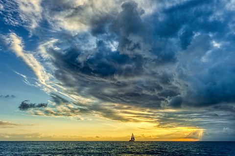 Stormy clouds gather over a sail boat.