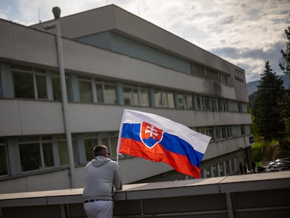 Un hombre ondeaba una bandera de Eslovaquia en el hospital en el que está ingresado Robert Fico, este jueves en Banska Bystrica.