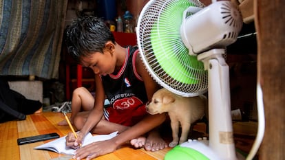 Un niño hace los deberes en su casa en Manila (Filipinas).