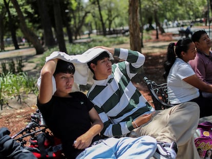 Jóvenes usan una prenda para hacerse sombra, el 16 de abril en la Alameda Central, en Ciudad de México.
