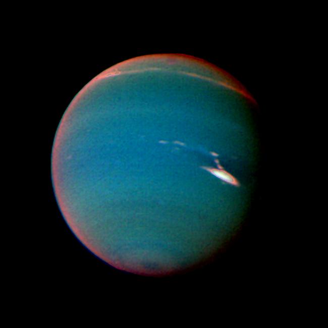 In this false color image of Neptune, objects that are deep in the atmosphere are blue, while those at higher altitudes are white. The image was taken by Voyager 2 wide-angle camera through an orange filter and two different methane filters.