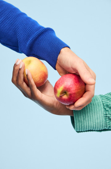 Two hands holding apples