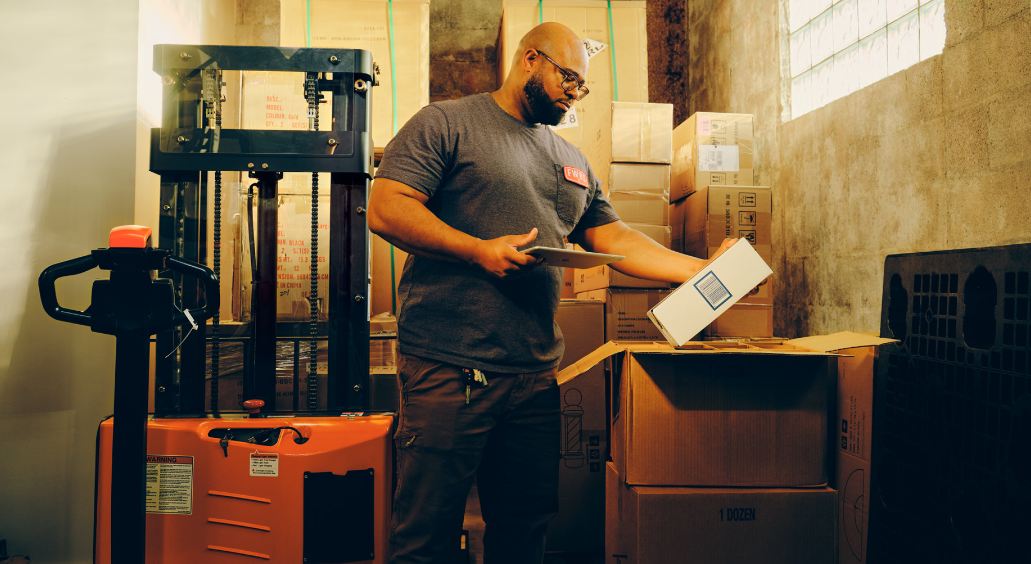 A person in a warehouse holds a box with their left hand and an iPad with their right hand while taking inventory on the device. A diagram to the right of the image shows the features of the Square Inventory platform.