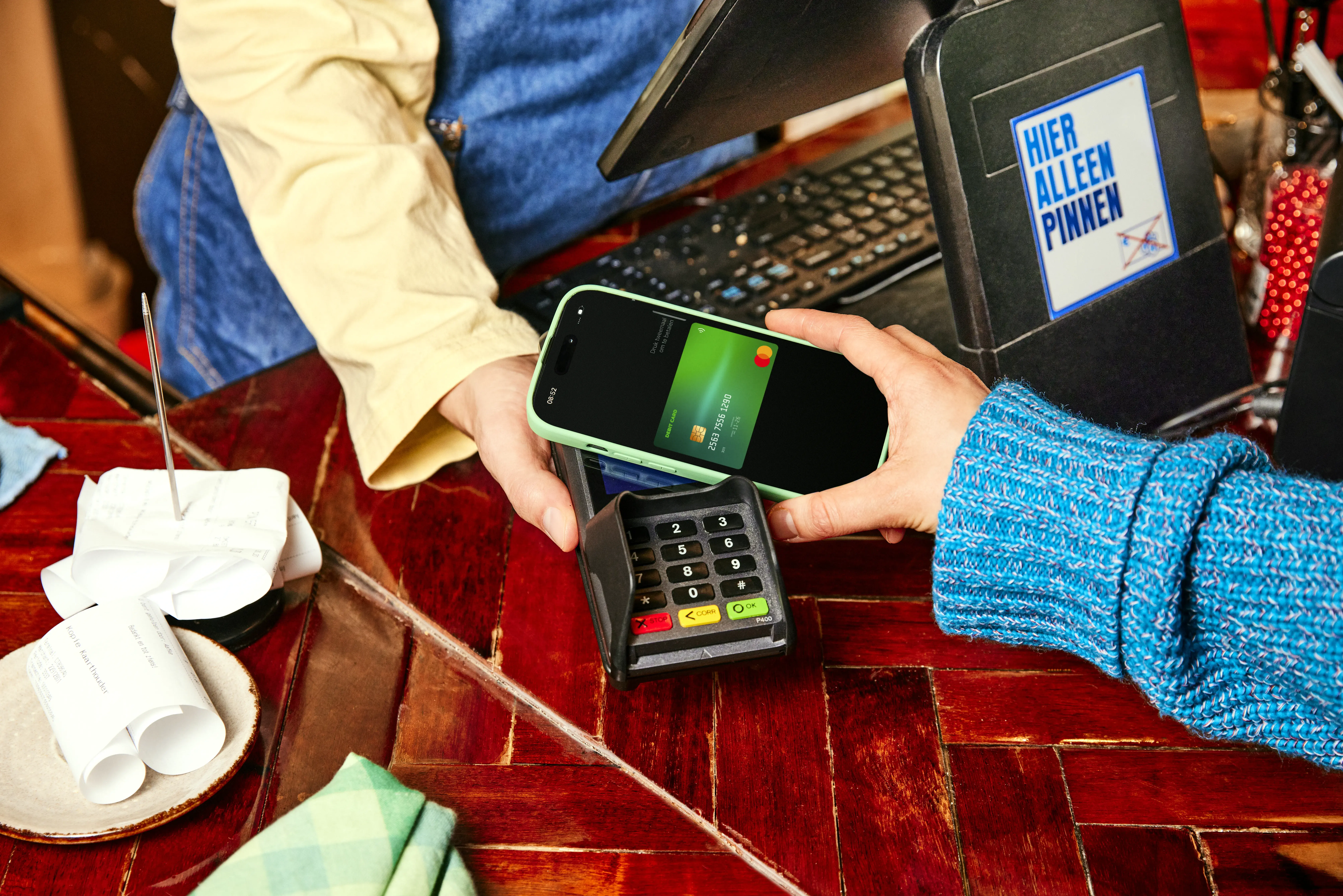 Contactloos betalen met een mobiele telefoon bij een kassa