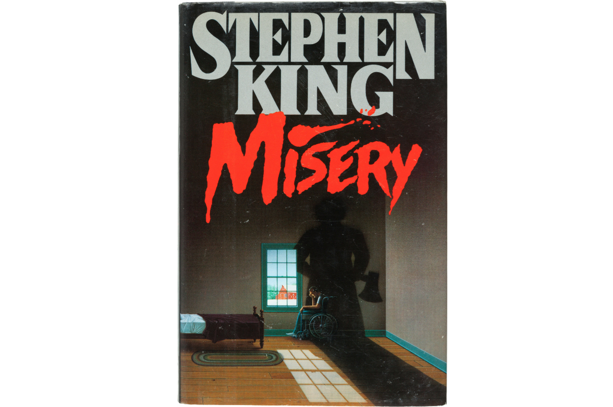 Cover of Stephen King&#x27;s &quot;Misery&quot; featuring title and a dark figure in a room with a wheelchair