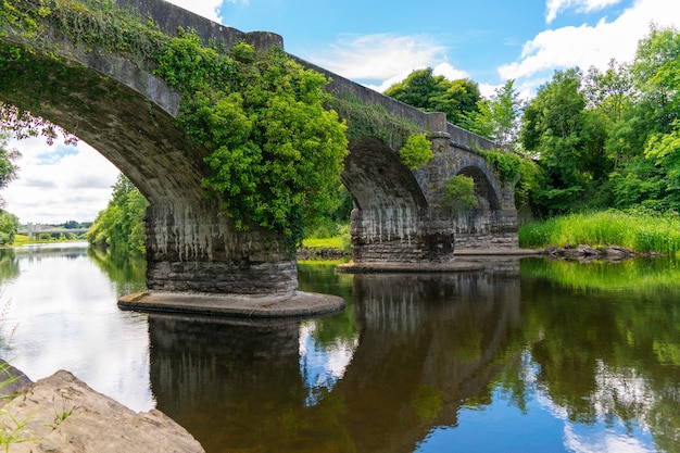 Vue d'un vieux pont d'arc avec sa réflexion sur la rivière
