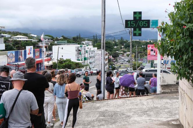 People wait in line to enter a pharmacy that remained open in the Magenta district of Noumea on May 15, 2024.