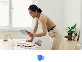 Une femme penchée sur son bureau regarde ses distinctions et récompenses sur sa tablette
