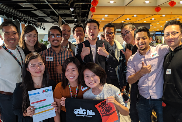 A group of Asian Googlers smile at the camera