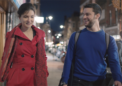 Founders, Elina and Adam, are walking along a sidewalk at night.