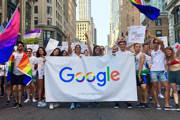 A group of Googlers carry a Google Pride flag at a Pride parade