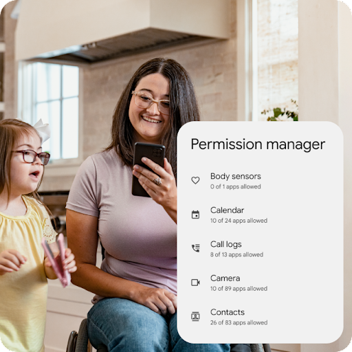 A parent in a wheelchair smiles looking at an Android phone while their child sings and dances. A graphic overlay highlights the details of Permission manager, including the number of apps allowed access to body sensors, calendar, call logs, camera and contacts.