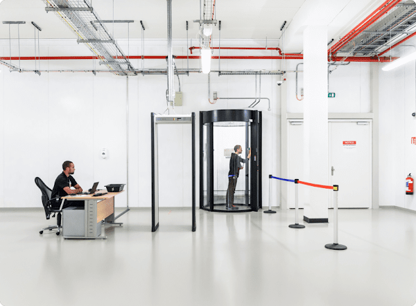 Interior of a Google Cloud data center showing a security guard and another person going through a secure entry that requires multiple layers of security protocols.