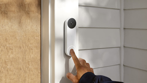 An image of house visitor pressing the button of a smart video doorbell