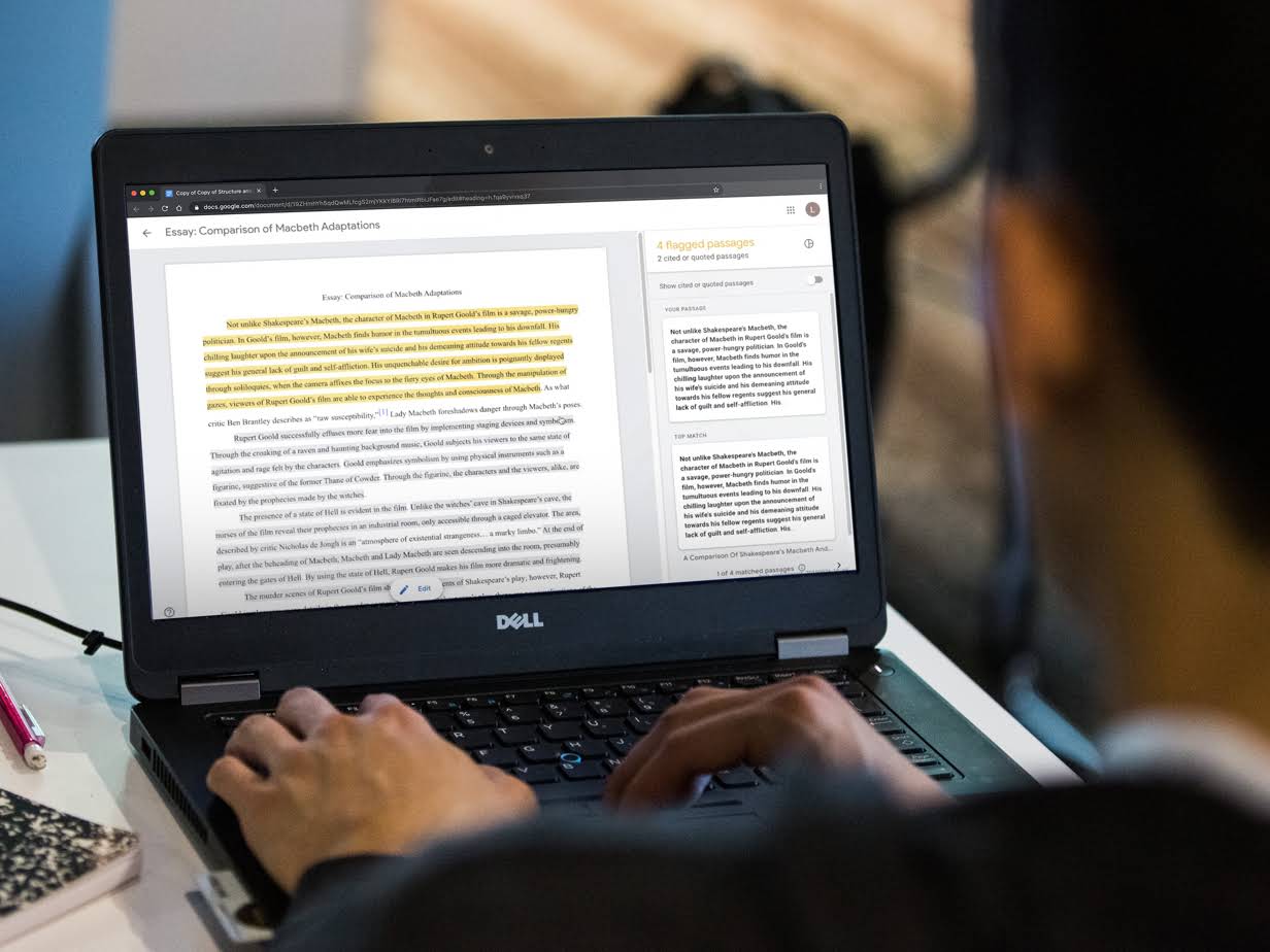 Een leerling typt op een Chromebook. Op het scherm werkt een leerling aan een opstel waarvan sommige passages zijn gemarkeerd in de rechterkolom.