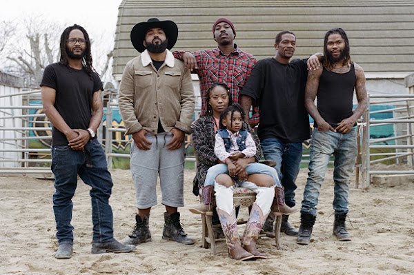 The Compton Cowboys posing for a photo in their backyard ranch with Keiara’s daughter Taylor on her lap.