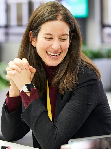 Woman wearing a black top, laughing.
