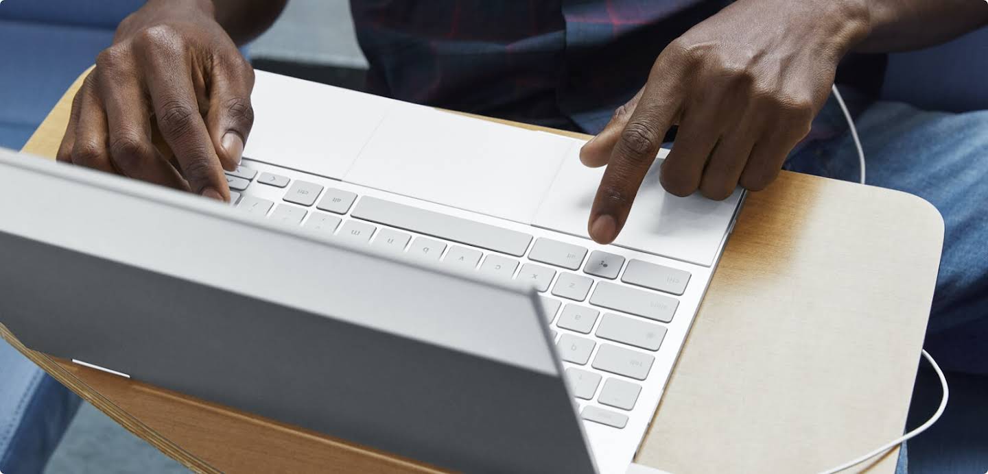 Mains tapant sur le clavier d'un ordinateur portable.
