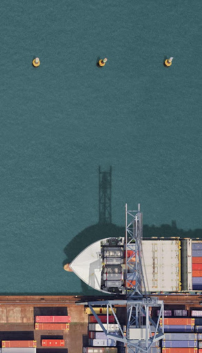 Aerial view of a commercial ship offloading containers at a commercial port