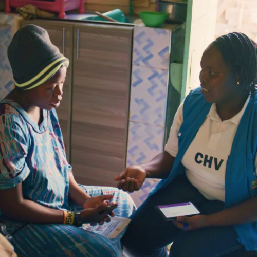 Una trabajadora sanitaria de Kenia se sienta con una mujer embarazada y utiliza una aplicación de salud materna llamada Mama’s Hub, creada con Open Health Stack.