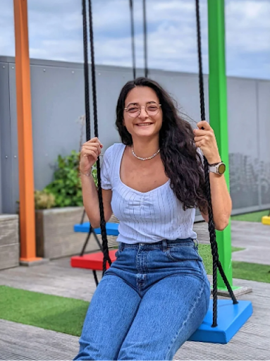 Lauriane, a Googler ads expert, smiles, swinging on a rooftop playground at the Google Dublin office