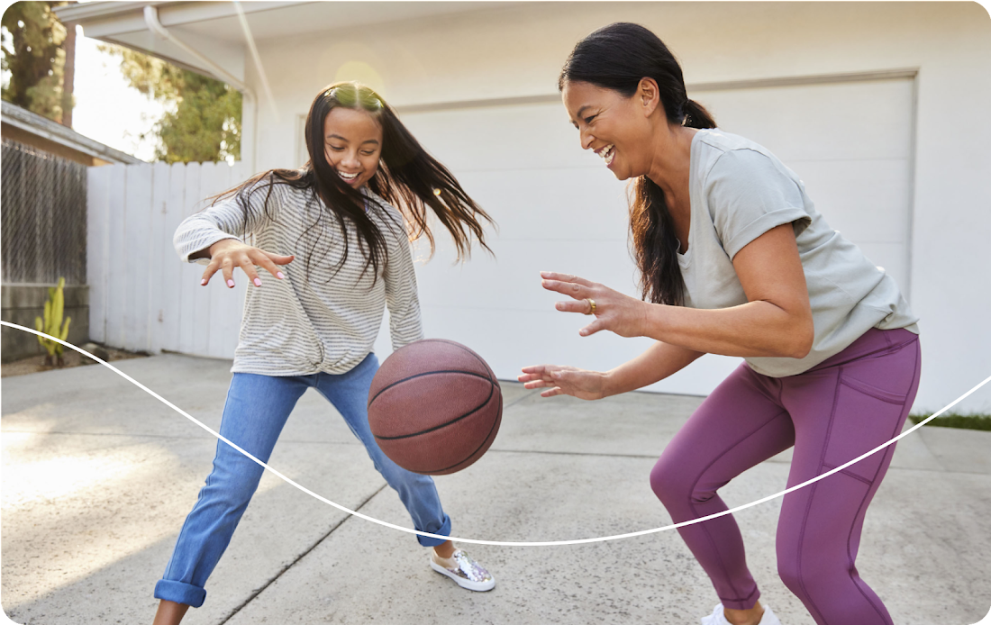 Daughter and mother playing basketball