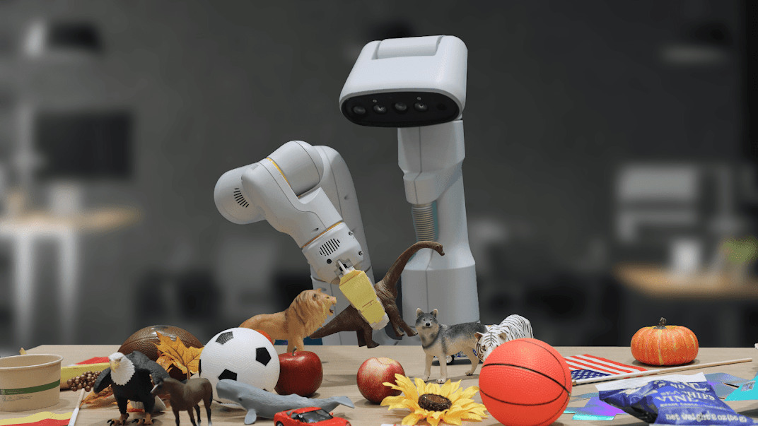 Robotic arm picking up a toy dinosaur from a diverse range of toys, food items, and objects that are displayed on a table.