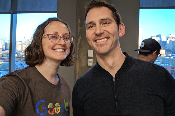 Two Googlers stand together and smile