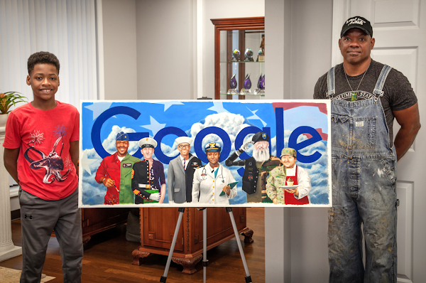 A man and his son stand alongside a print of a Google Doodle depicting six veterans from different branches of the military