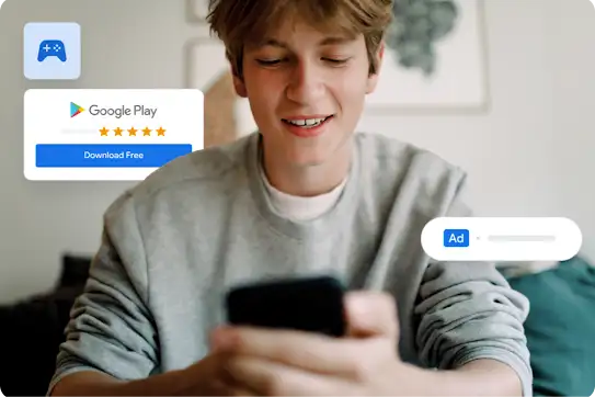 A young man smiles while typing on a smartphone; he’s encircled by Google product icons