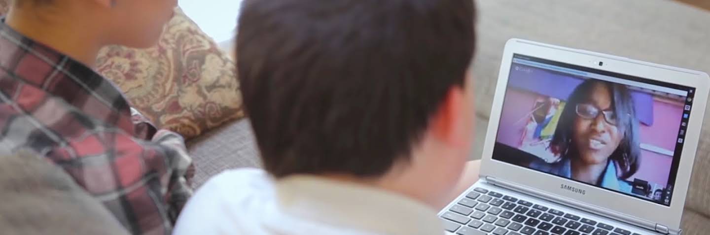 Two kids staring at a laptop