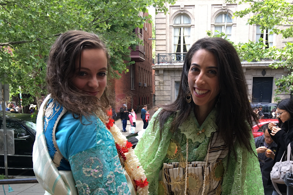 Two women from the CAMENA ERG wear traditional clothing and smile