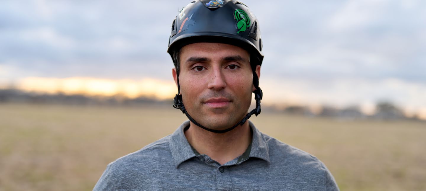 Headshot of Bourhan Yassin in a field wearing a helmet before he begins his tree climb
