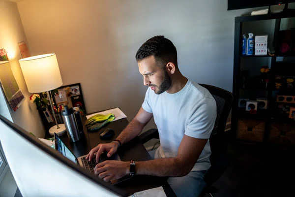 A man is working while sitting in his home office area and using high-speed GFiber internet.