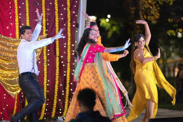 Four Googlers, three wearing traditional Indian clothing, dance on a stage