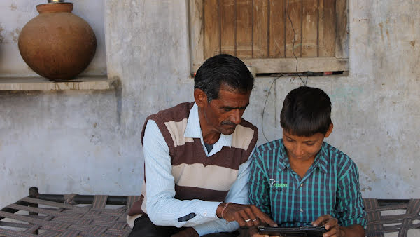 Man and a boy look at a tablet