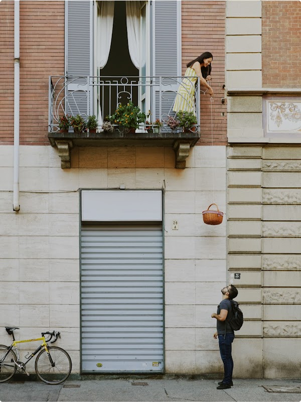 Mattia looks up as a customer lowers a basket from her balcony for her book delivery
