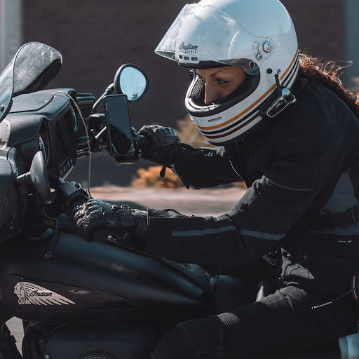 Woman in helmet riding a motorcycle.