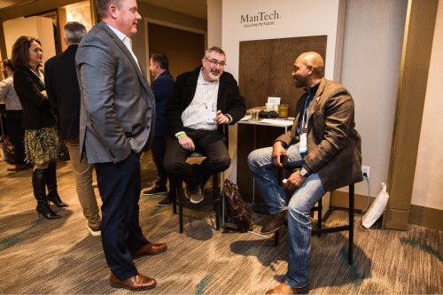 Three partners and Public Sector team members convening at a bar table inside an event space.