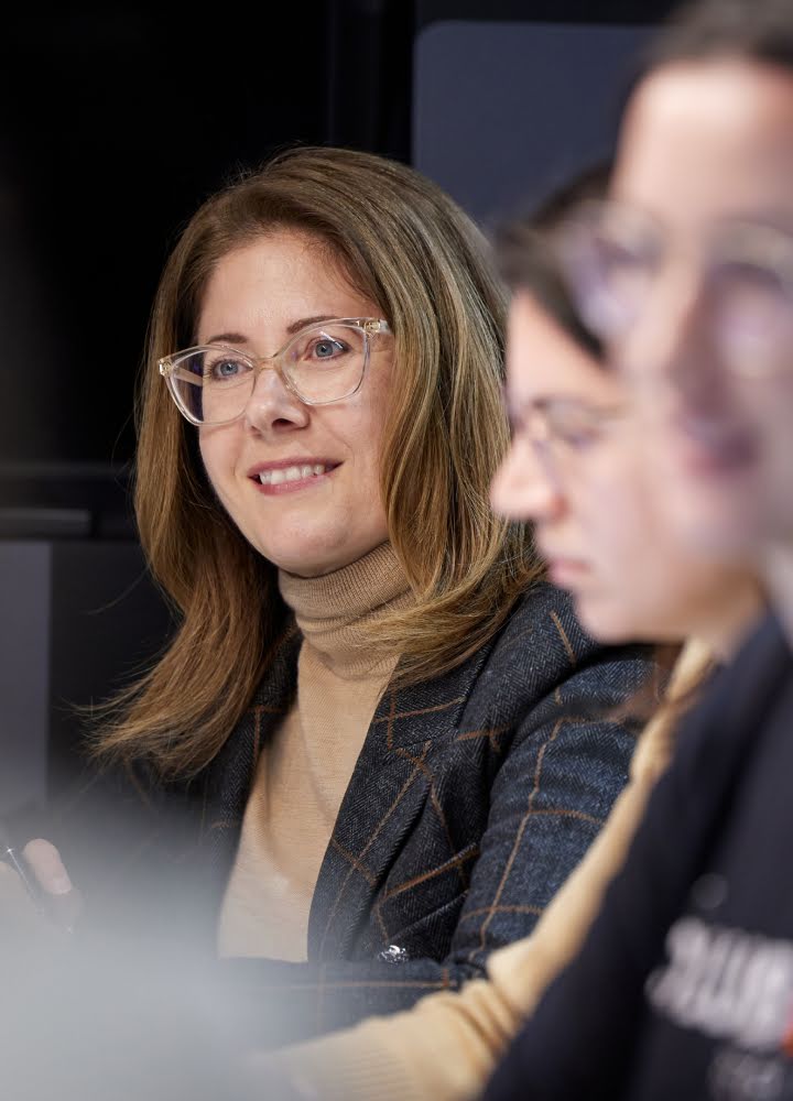 Photograph of Angela Siefer smiling and sitting alongside her team at NDIA