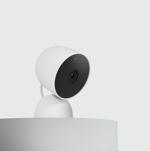 A Nest Cam sits on a shelf in a side profile.
