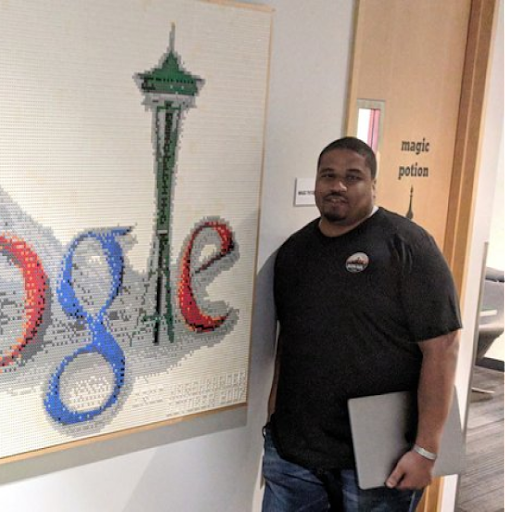 A man stands in front of a Google sign
