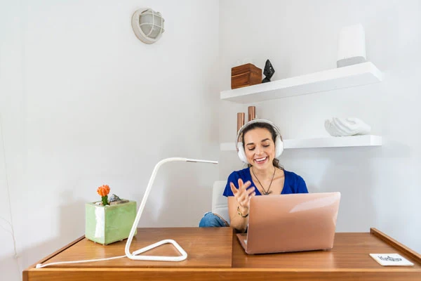 A woman is enjoying a video conference call from her home office on her laptop while using high-speed GFiber internet.