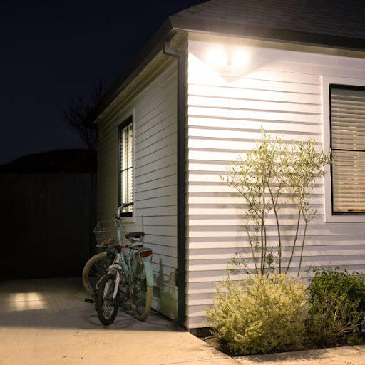 A floodlight shines outside of a house at night.