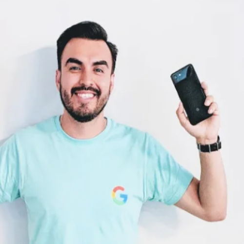 Latin American Googler smiles, holding up a Pixel