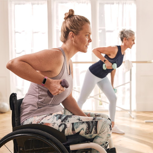 A woman with a disability working out with her friend in a fitness studio