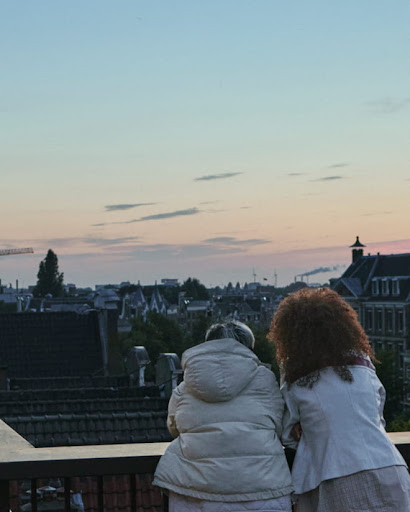 Two people enjoying a view of a city from a balcony