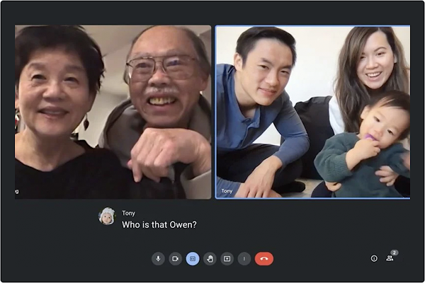 A screen shows two older adults speaking to a young family using Google Meet technology. This family includes Tony Lee- an Asian American man, his wife and son Owen. Captions on the screen show the conversation. “Wave hi” Tony’s wife says, Tony asks Owen “Can you wave?”