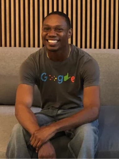Jerry sits on a couch inside a Google office, wearing a grey Google disability logo tee